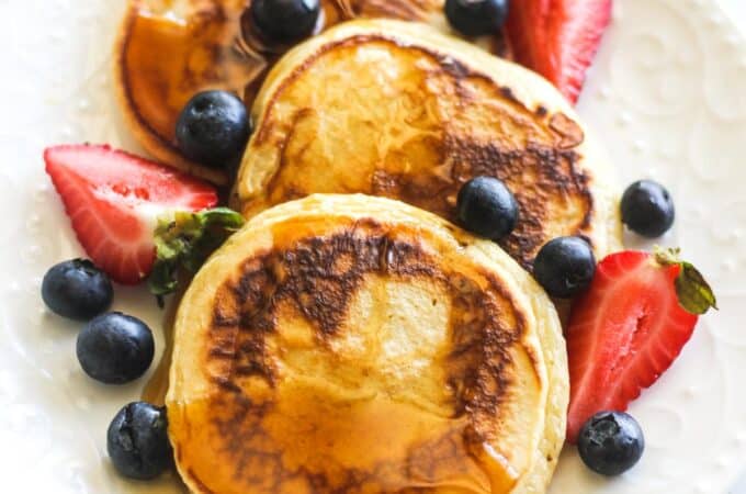 pancakes with maple syrup and berries on the plate