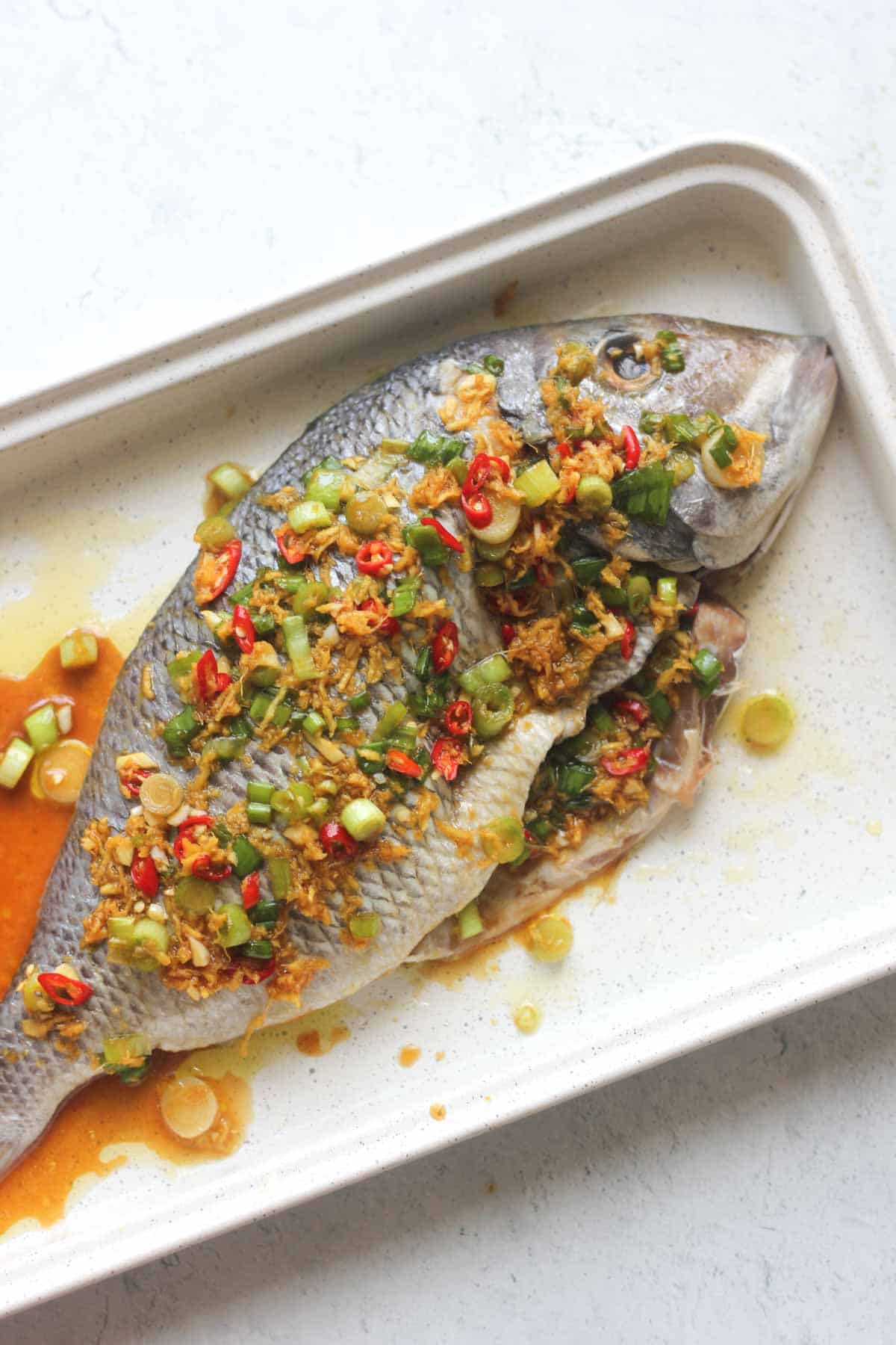 raw whole porgy with a mixture of spices on top