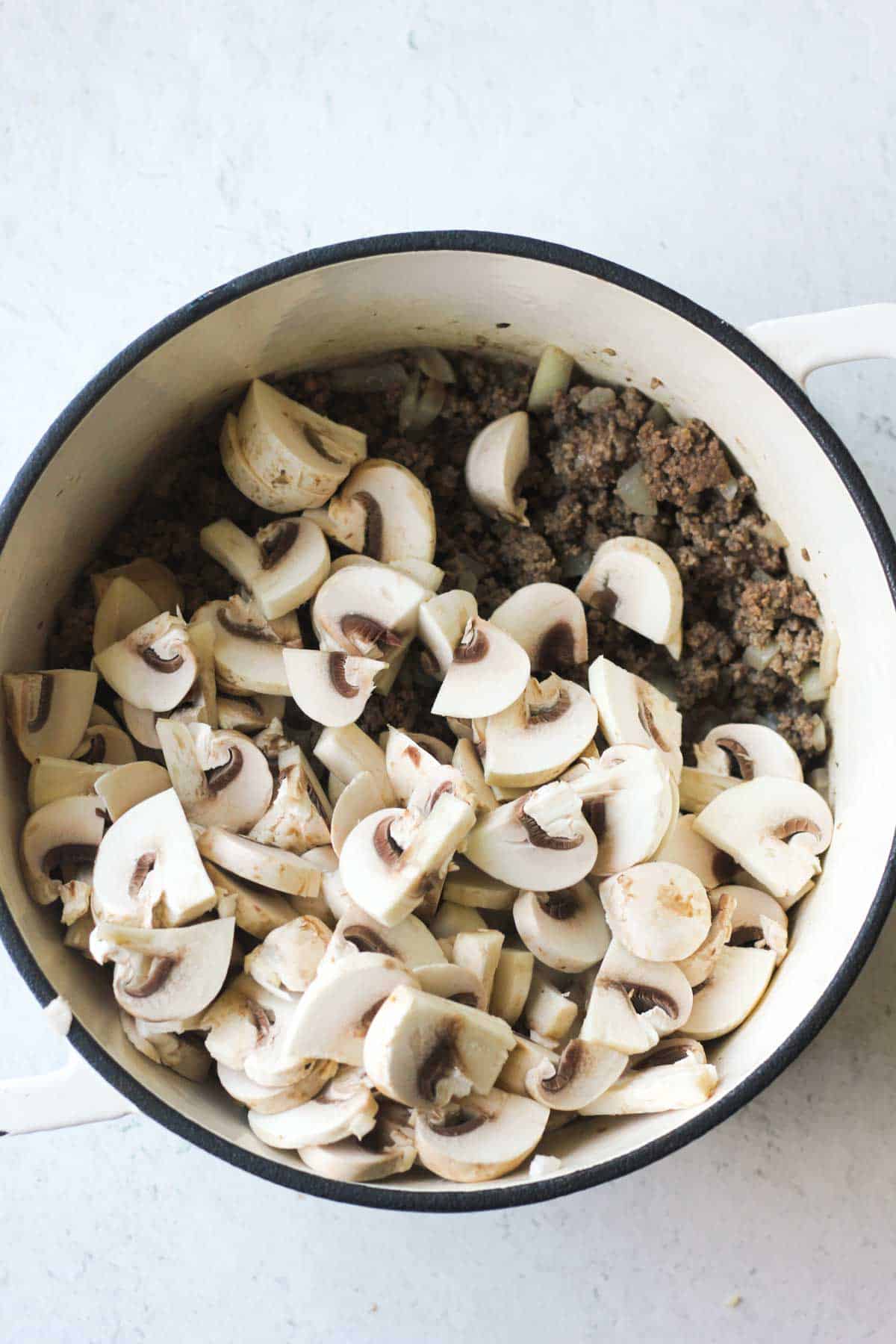 mushrooms and ground meat in the white pot