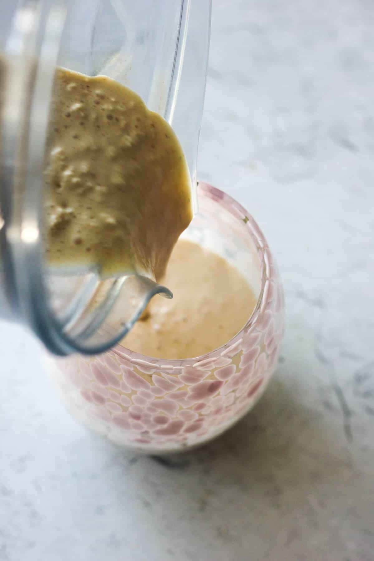 pouring cookie butter milkshake into the glass