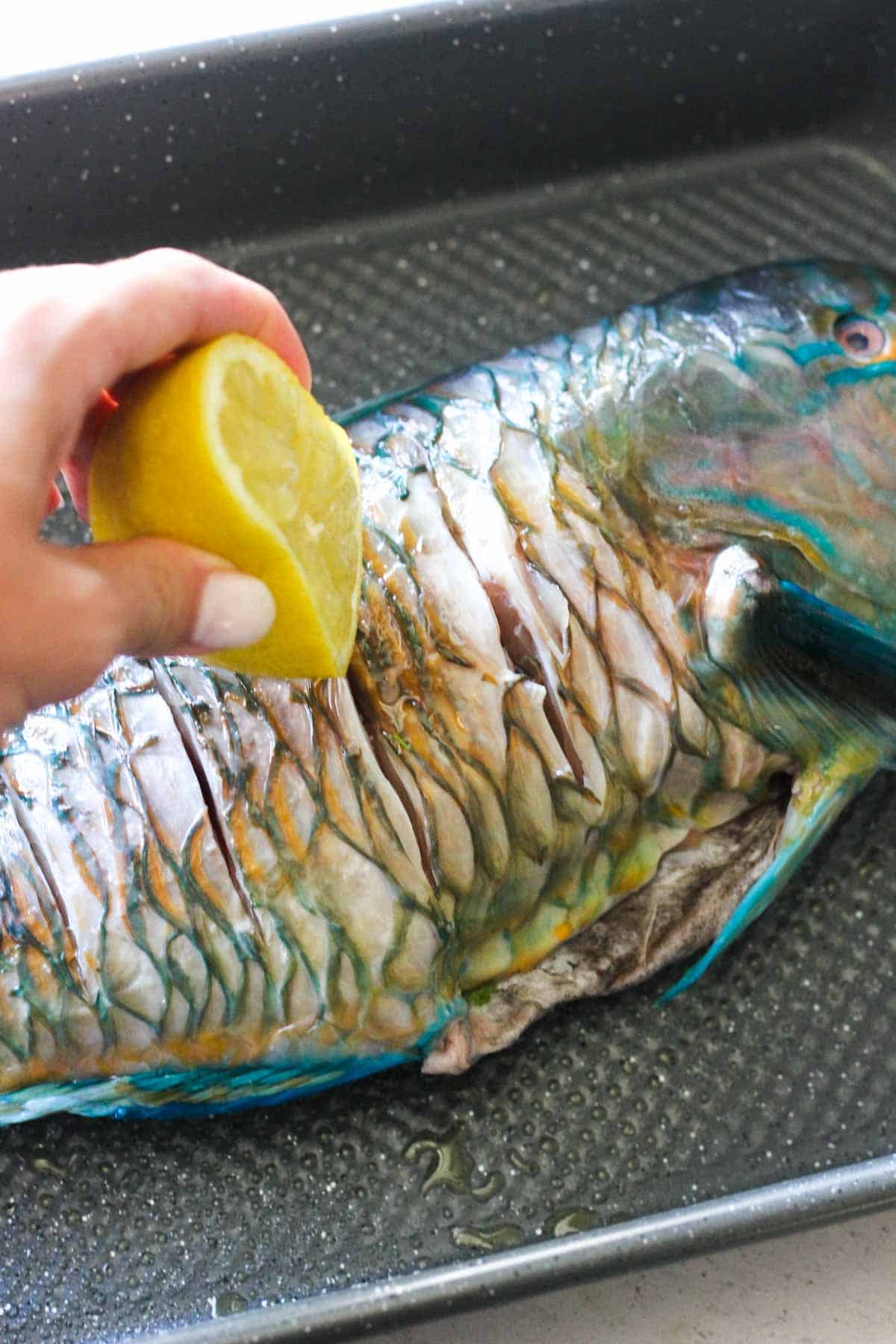 adding lemon juice to the raw parrot fish before baking