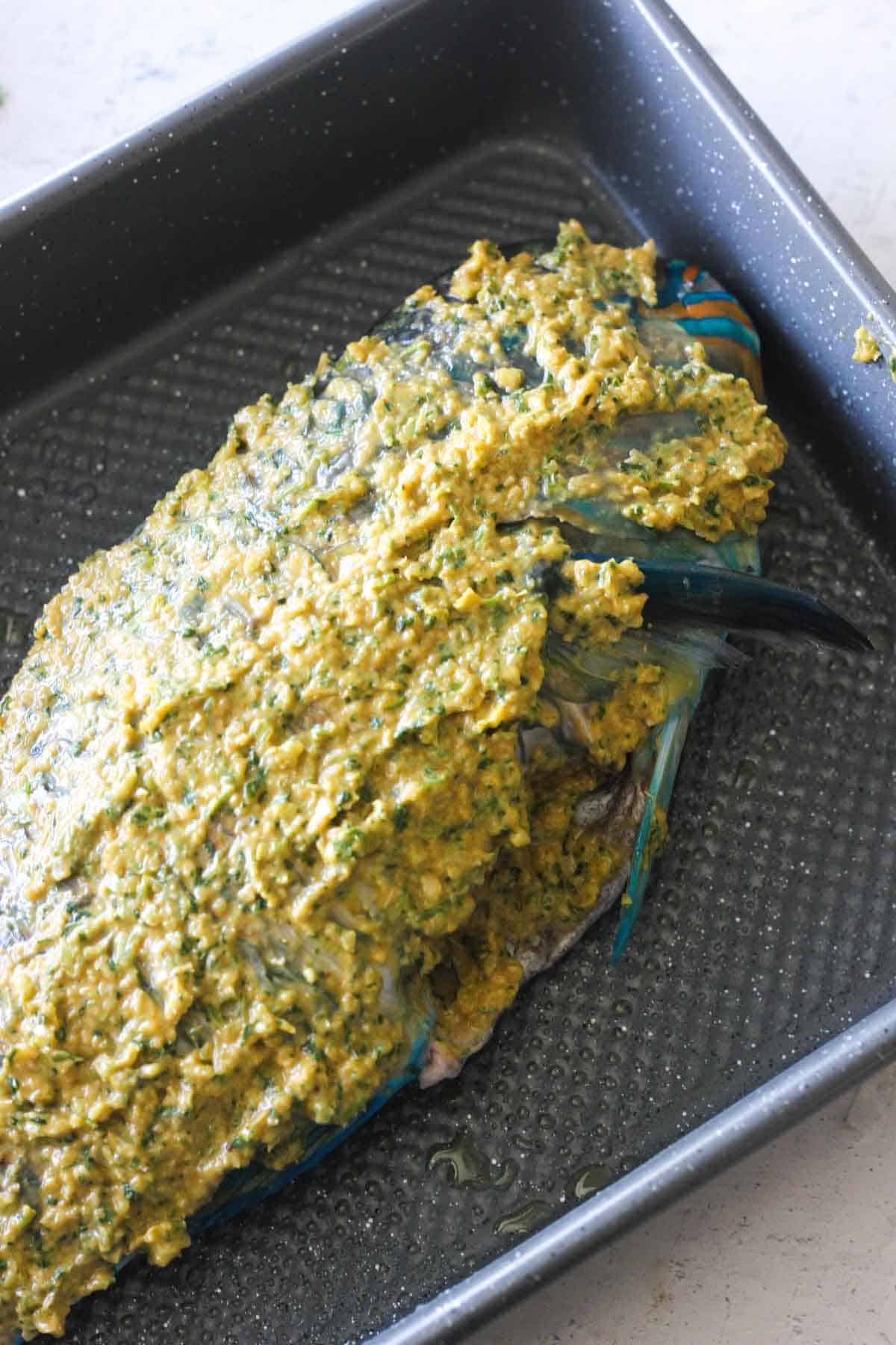 seasoned and marinated parrot fish in the baking tray