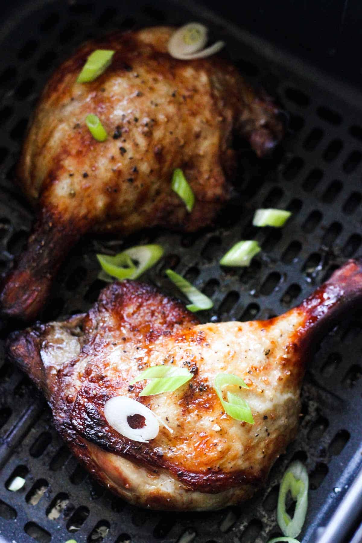 cooked duck legs in the air fryer with sliced scallions