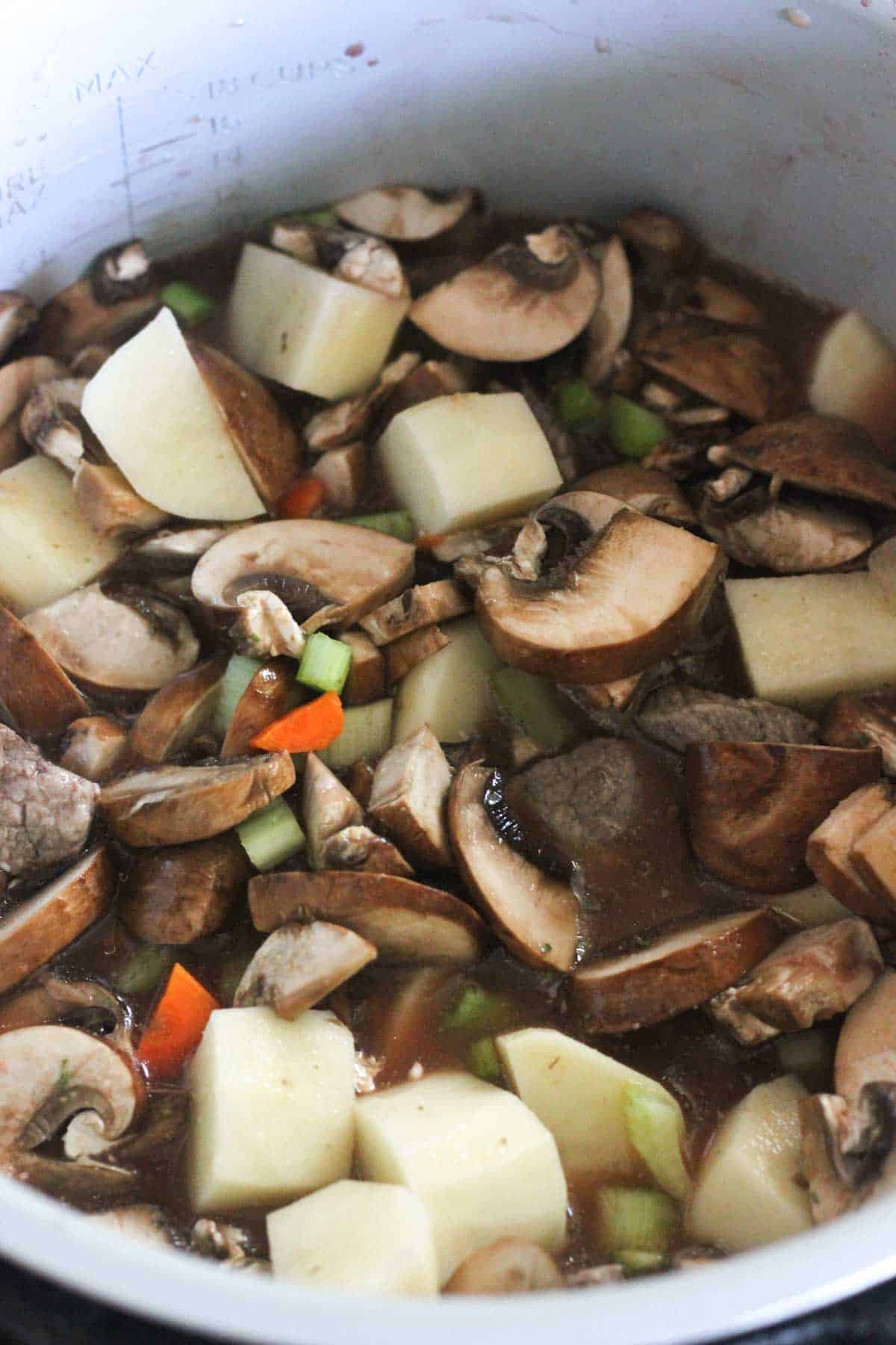 mushrooms , carrots and potatoes in broth in pressure cooker