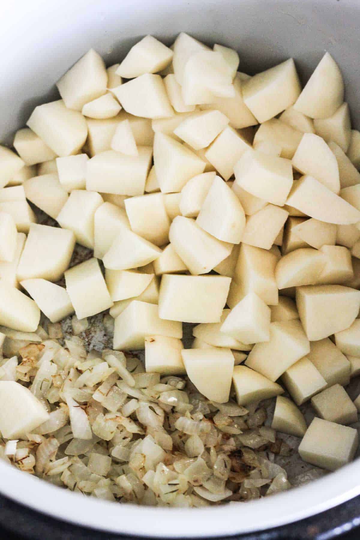 sauteed onions and cubed potatoes in the pressure cooker pot