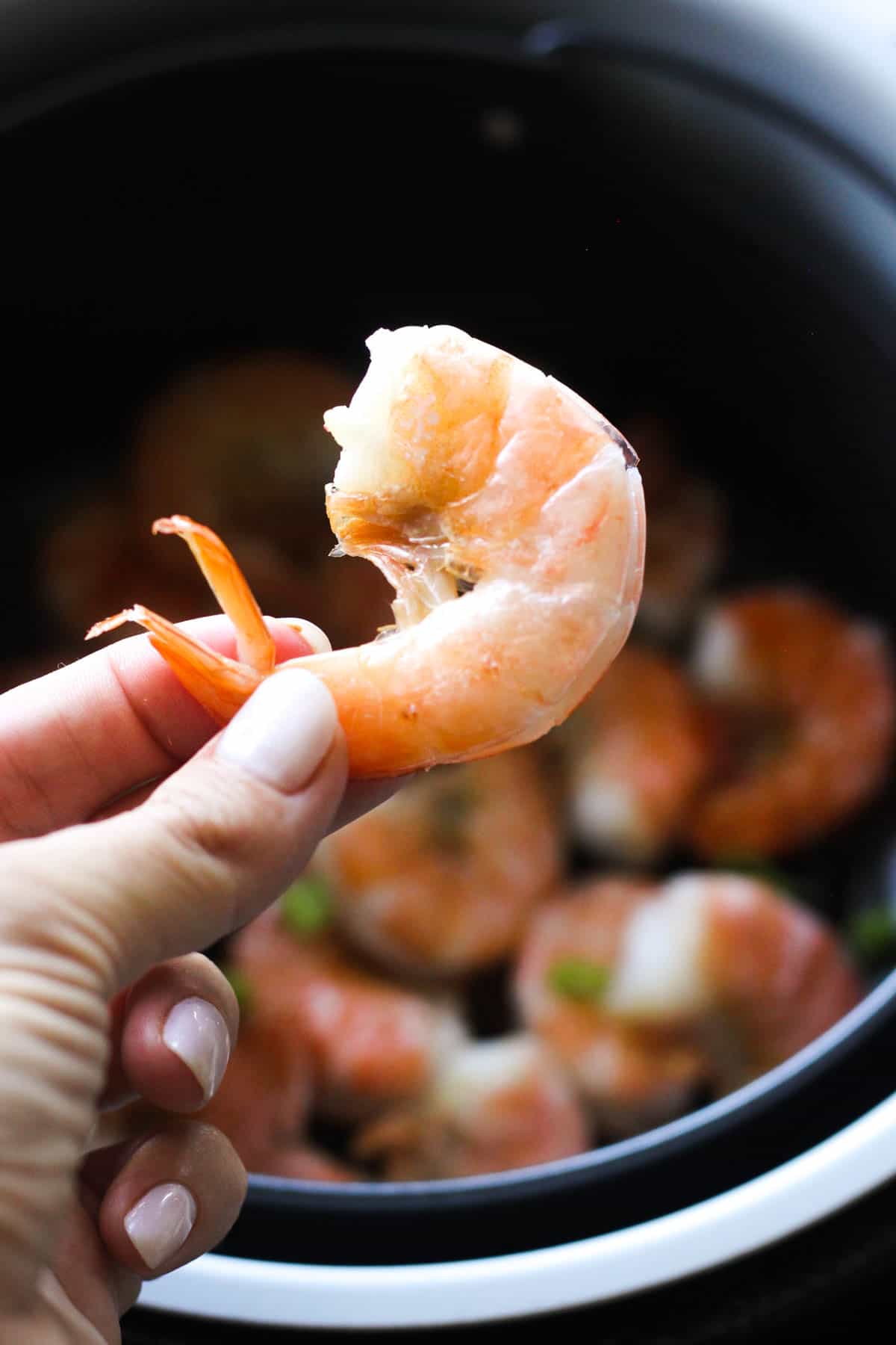 a piece of cooked shrimp in hand