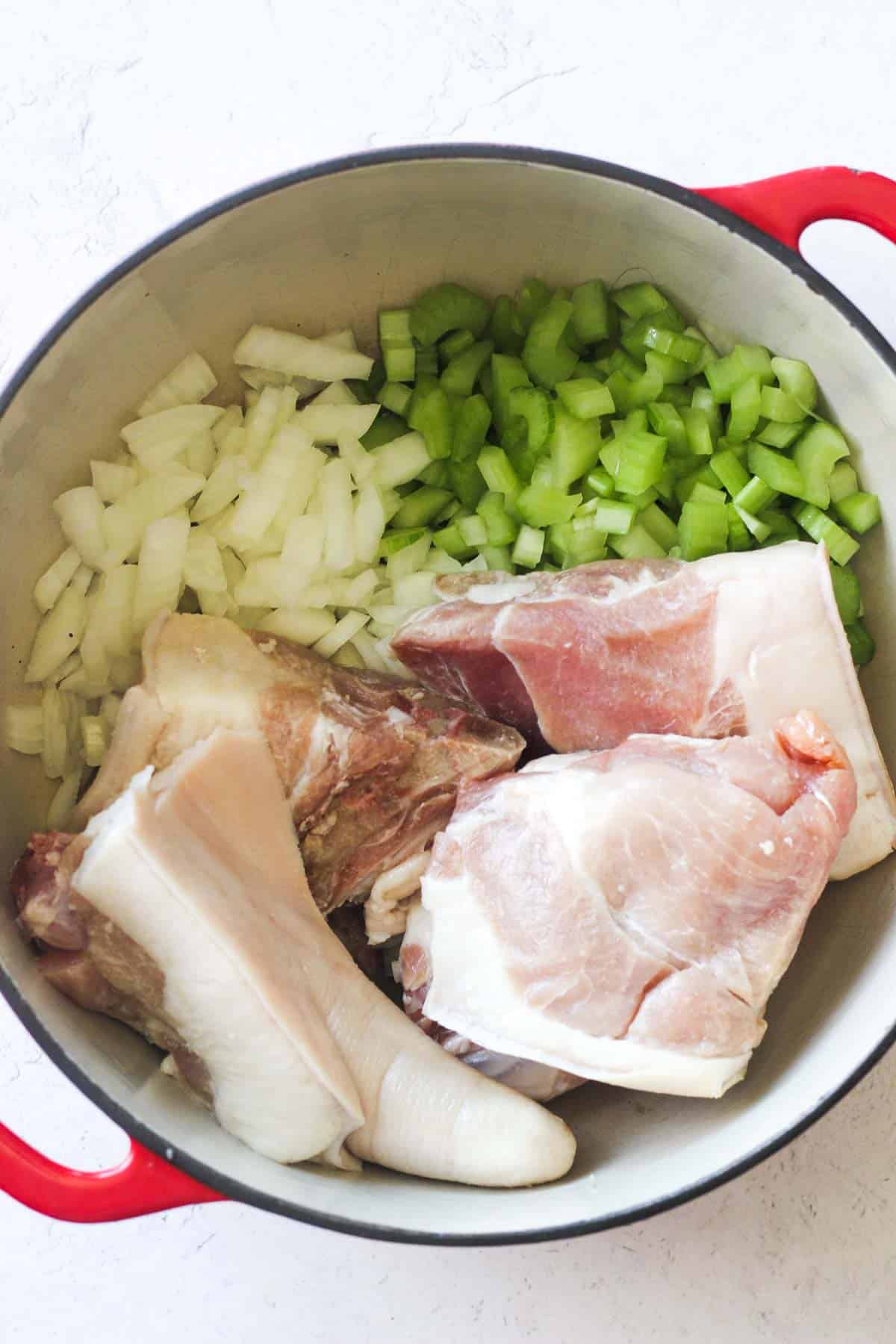 chopped celery, onion and sliced pork in the pot