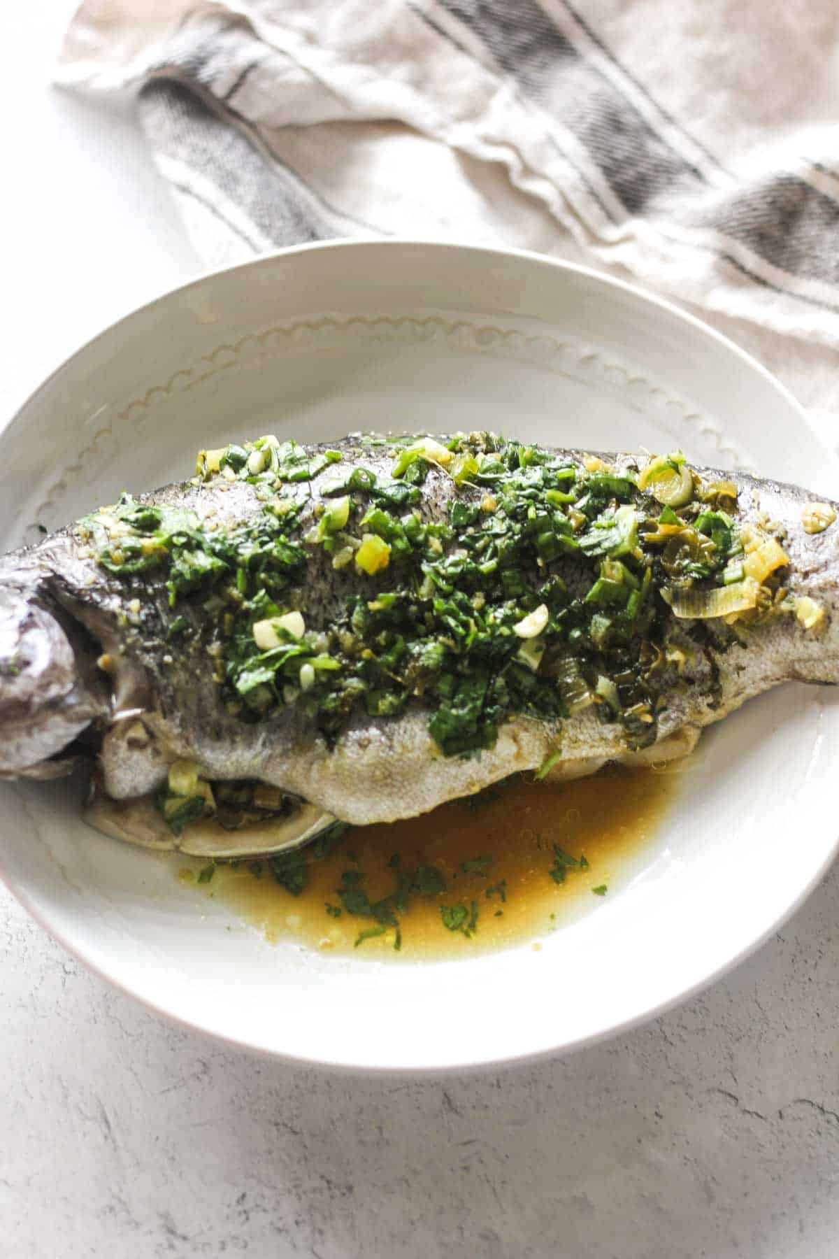 fish covered with green marinade on the plate