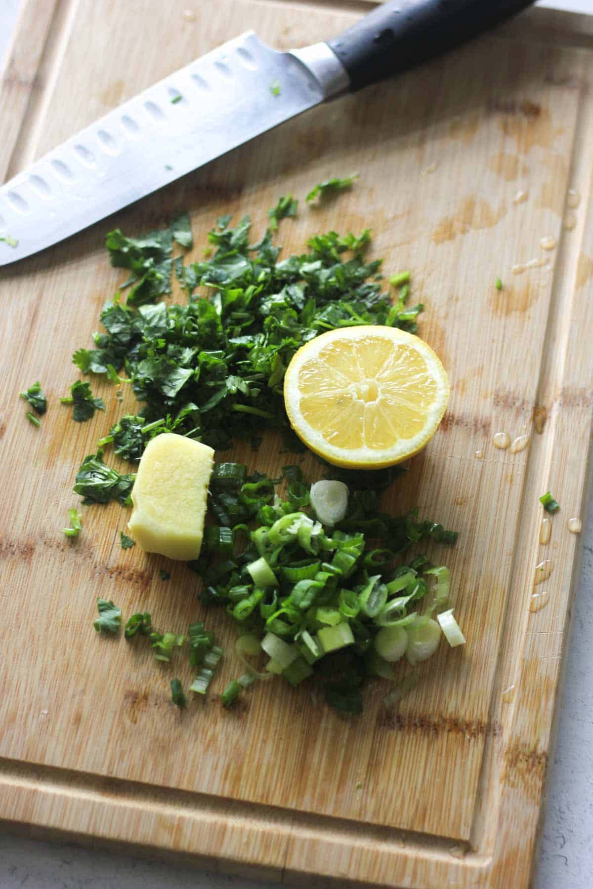 lemon, ginger, cilantro and green onions on the cutting board