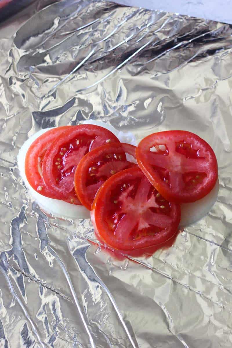 sliced onions and tomatoes on the foil