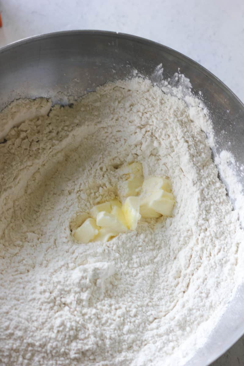 adding soft butter to the flour