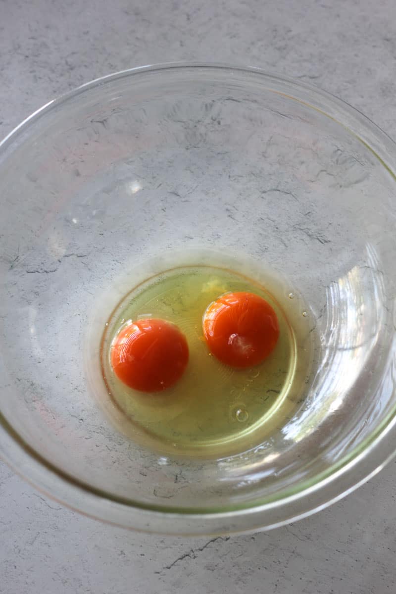 two raw eggs in the glass bowl