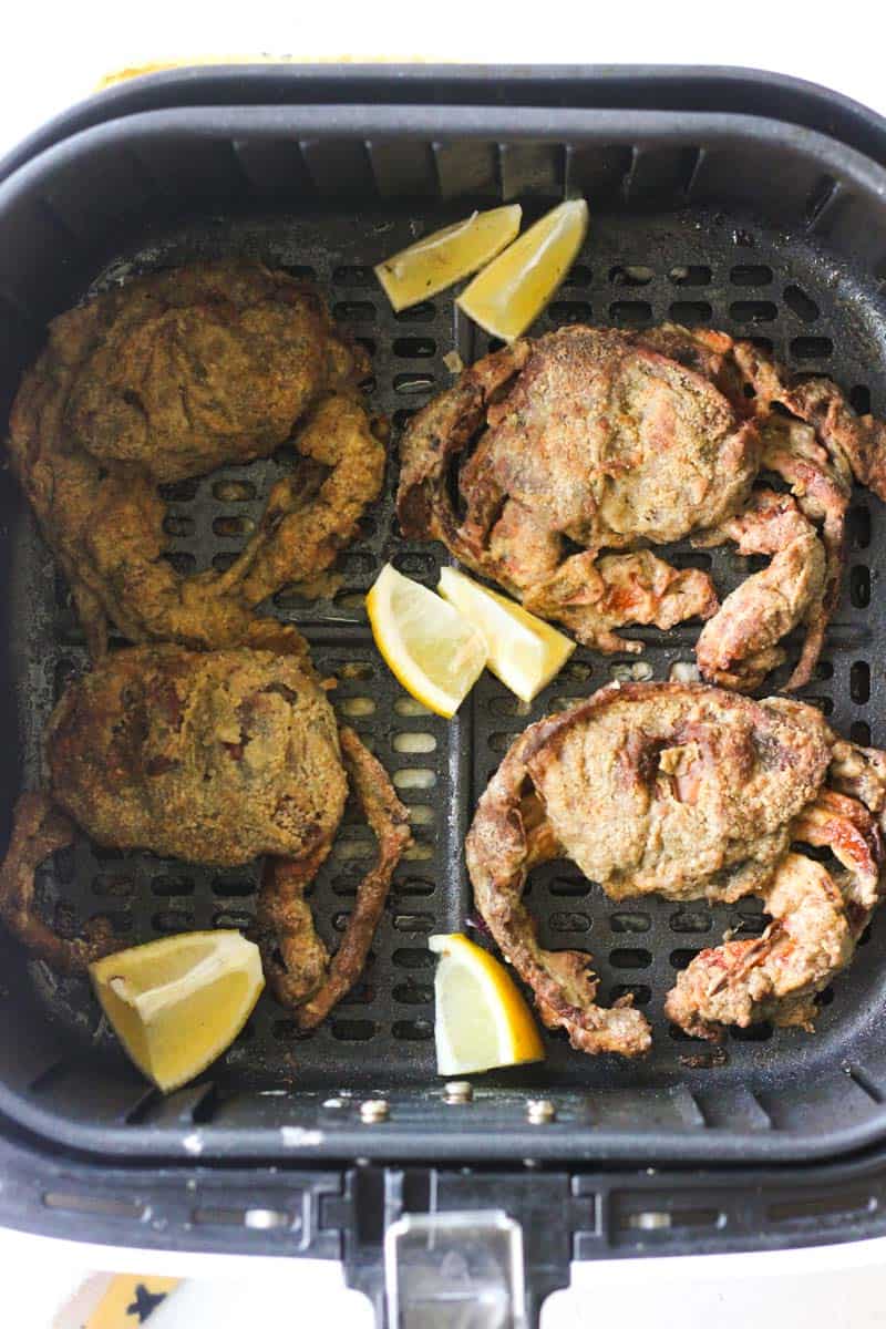 four soft shell crabs with lemon wedges in air fryer
