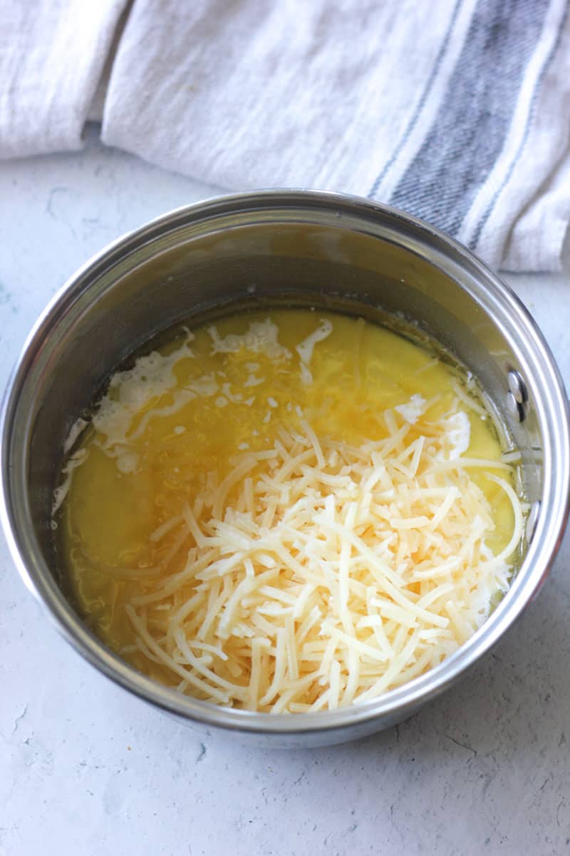 adding shredded cheese to the butter mixture