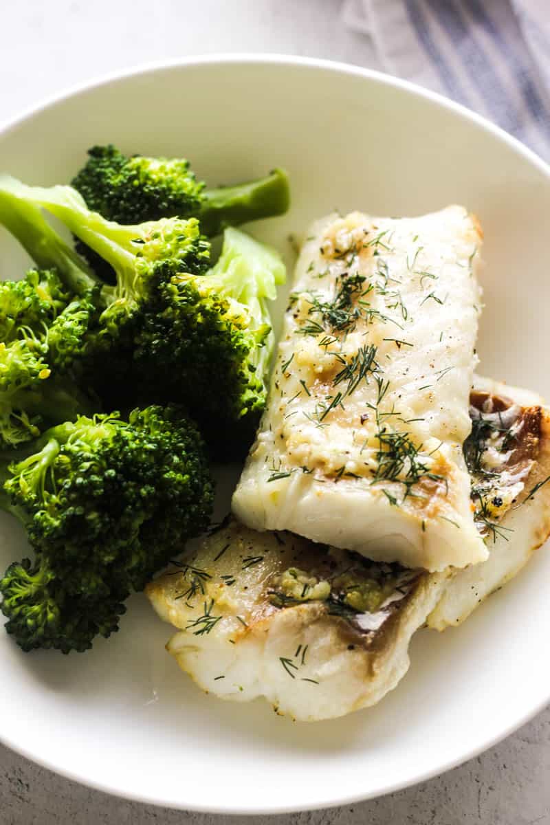 cooked air fried cod fillets with broccoli on the plate