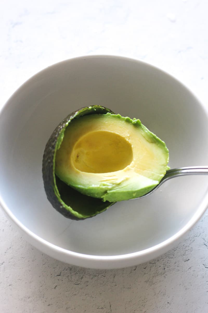 scooping avocado out of the skin