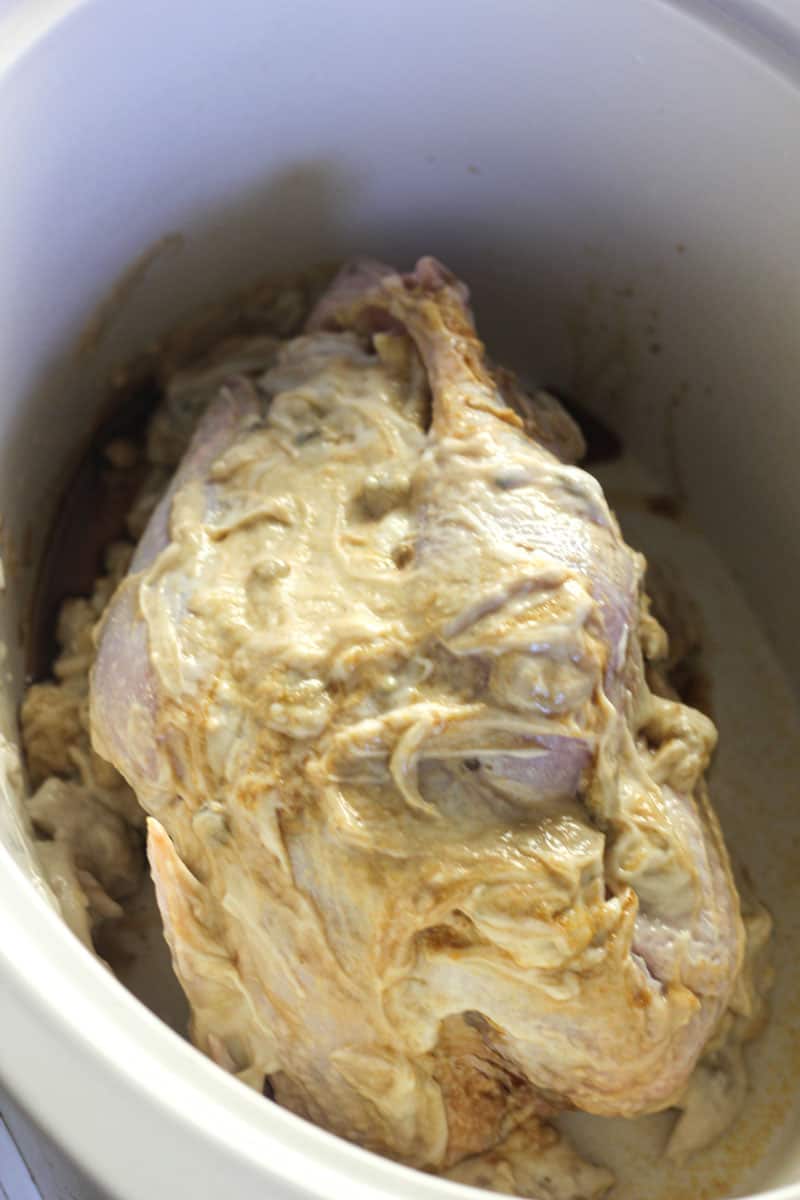 whole bird covered in cream of mushroom soup in slow cooker