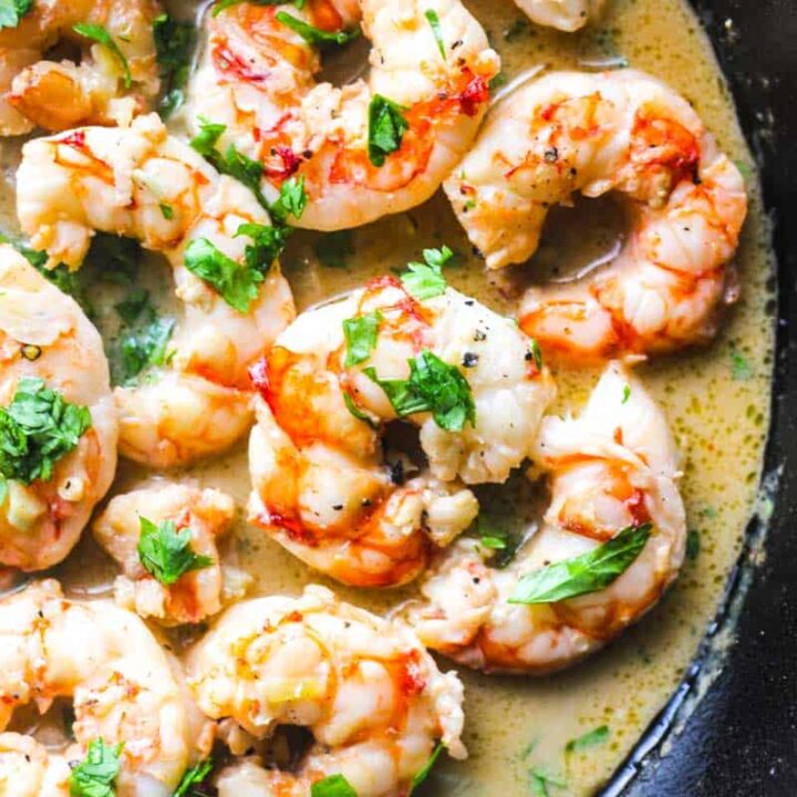 shrimp cooked in a skillet with scampi sauce