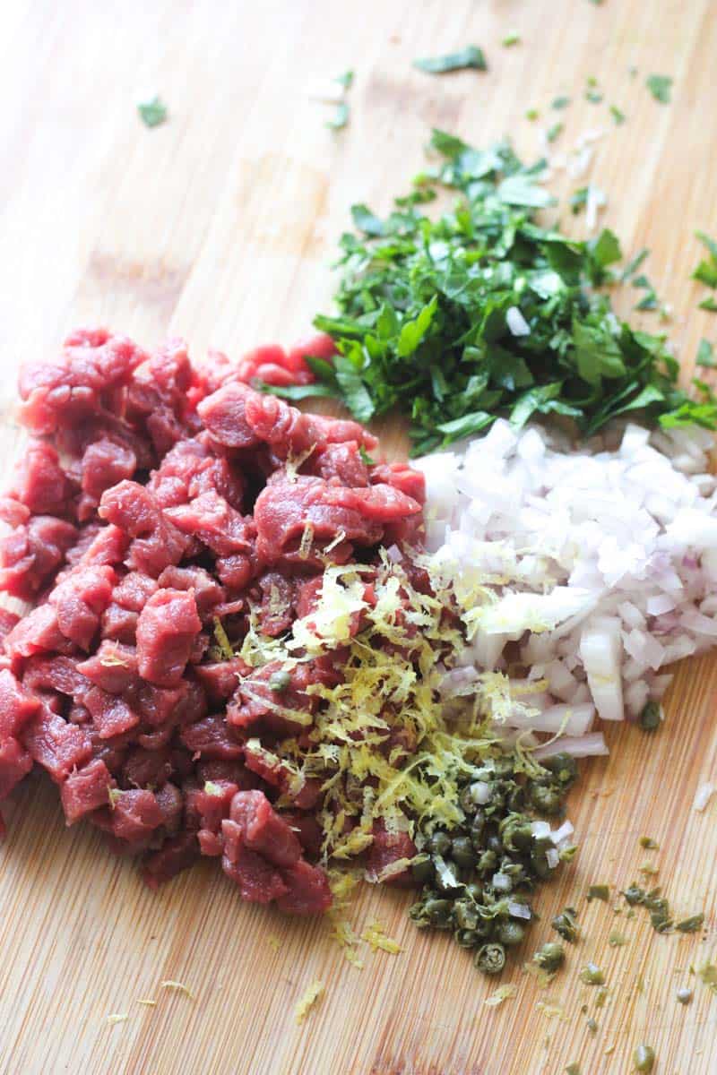 chopped meat with other ingredients on the cutting board