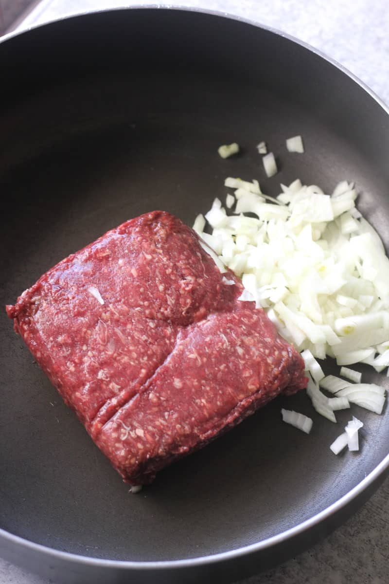 ground venison and chopped onions in the pan