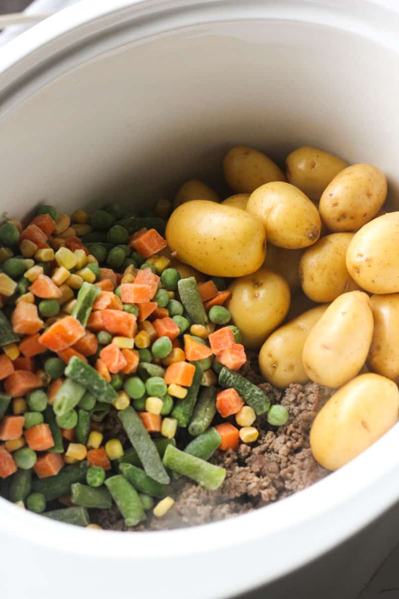 frozen veggies, meat and potatoes in slow cooker