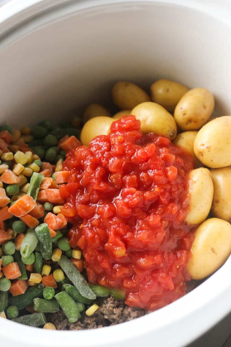 stewed tomatoes on top of meat and potatoes
