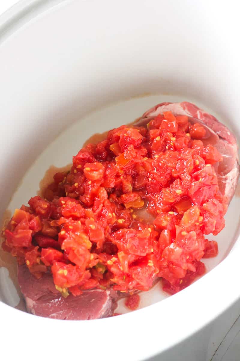 diced canned tomatoes on top of london broil in slow cooker