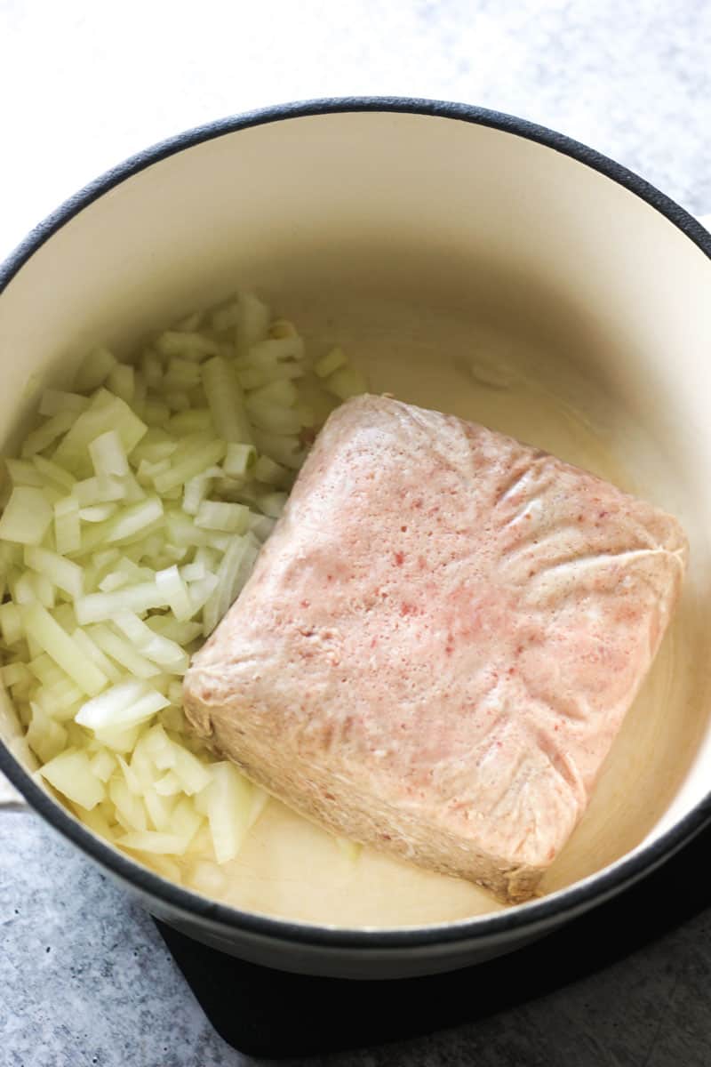 a block of ground wild boar and chopped onions in the pot