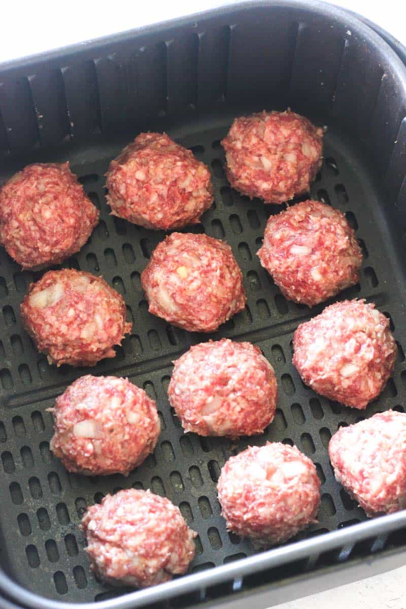 raw ground lamb meatballs in air fryer basket