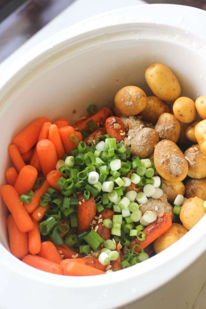 potatoes, carrots and chopped green onions in a pot