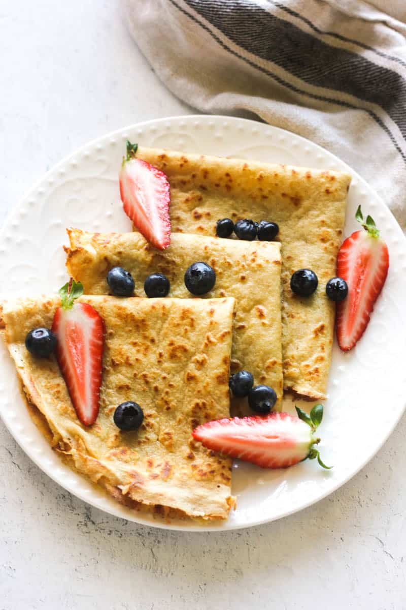 kodiak cakes crepes with berries on top on a white plate