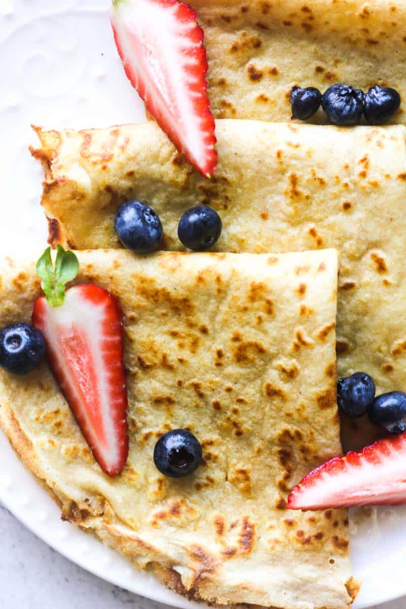 three kodiak cakes crepes folded in triangle with berries on top