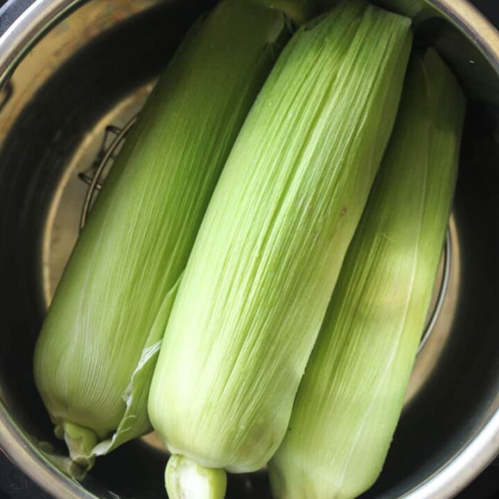 three ears of corn in the pressure cooker pot