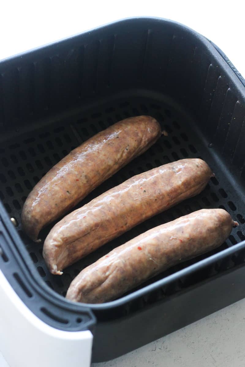 raw meat sausages in air fryer basket