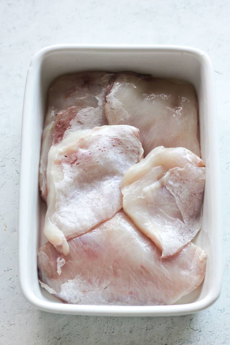 raw grouper cheeks in a white baking dish