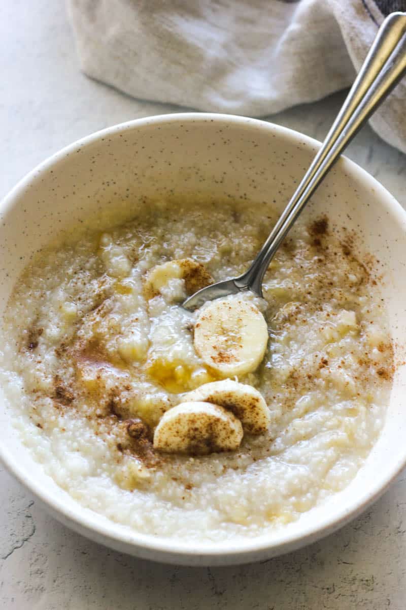 porridge with bananas and honey in a white bowl