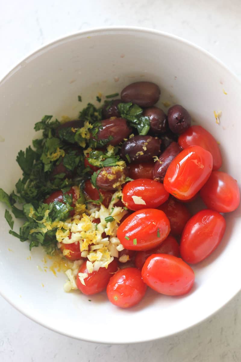 cherry tomatoes, chopped garlic and chopped cilantro in the small white bowl