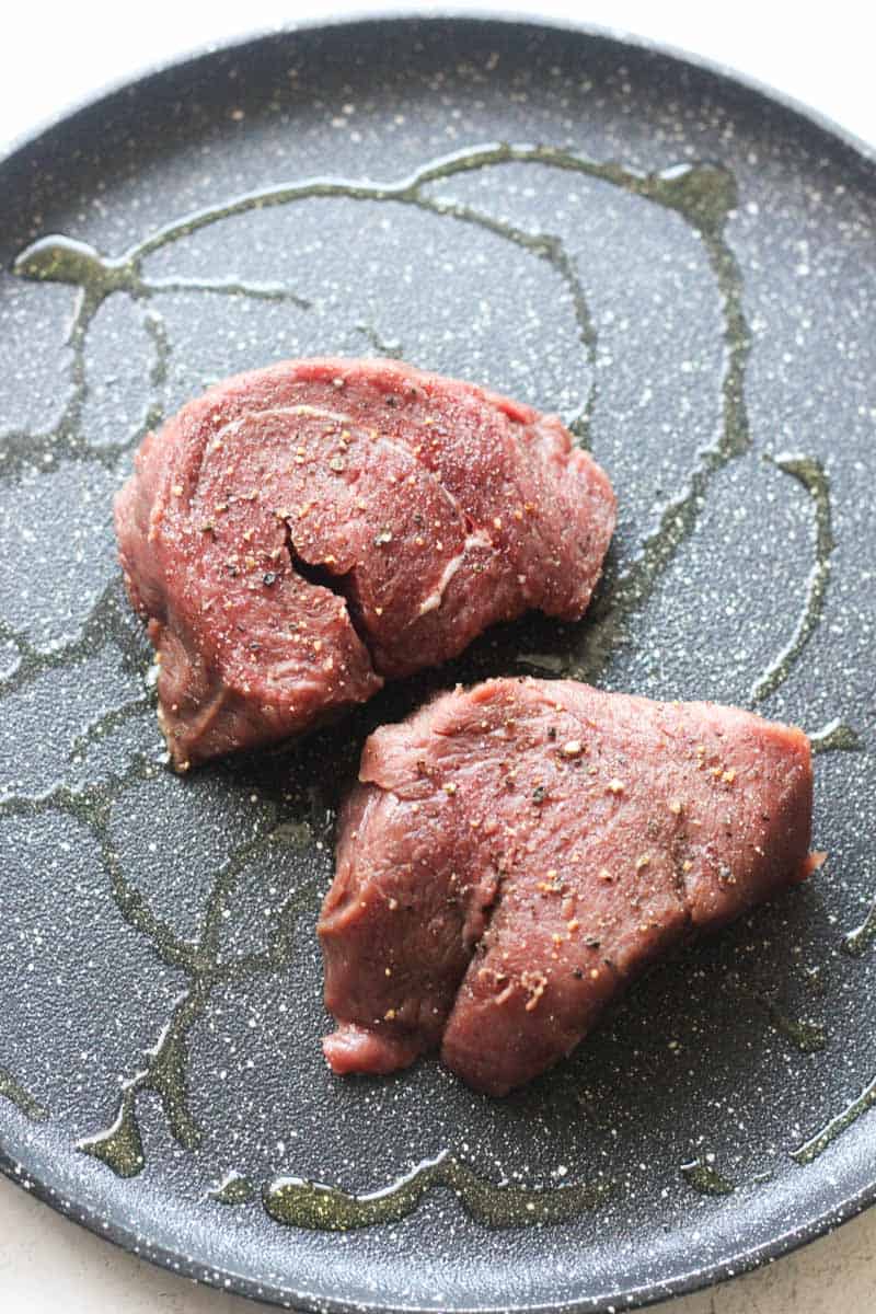 raw seasoned meat loins on the hot pan