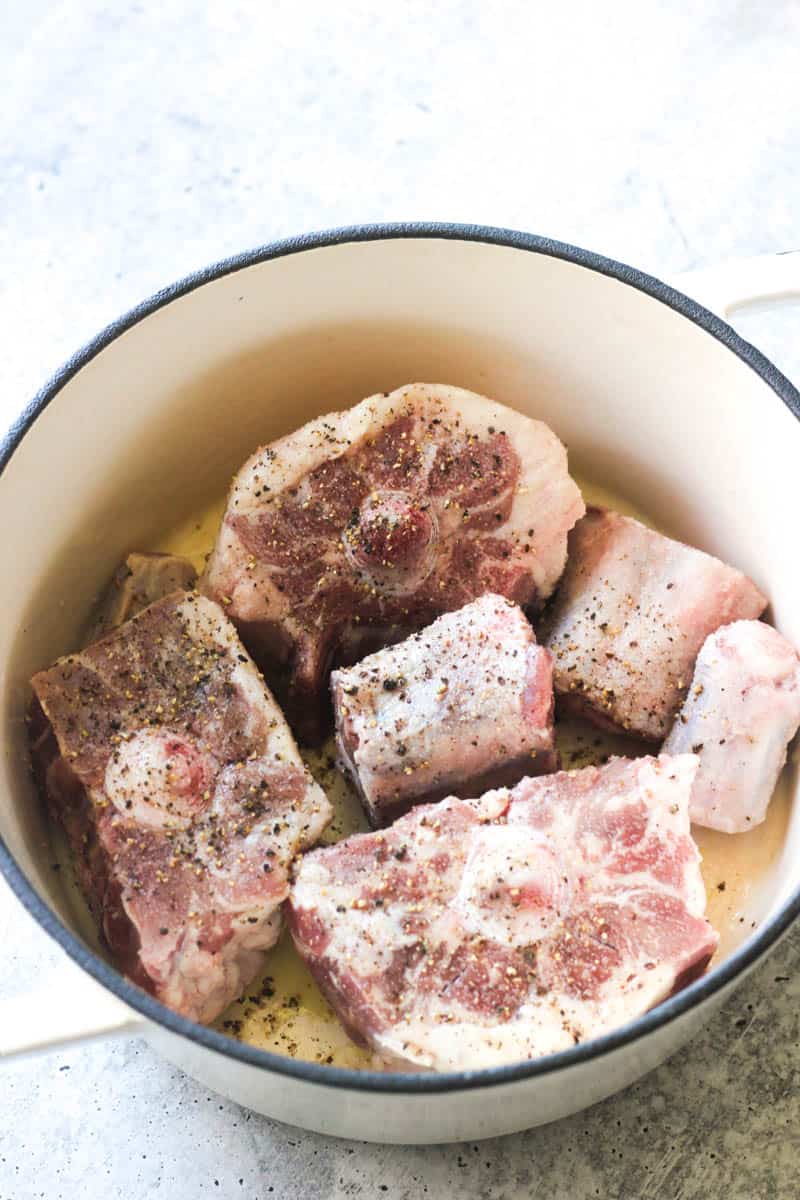 raw seasoned oxtails in the pot