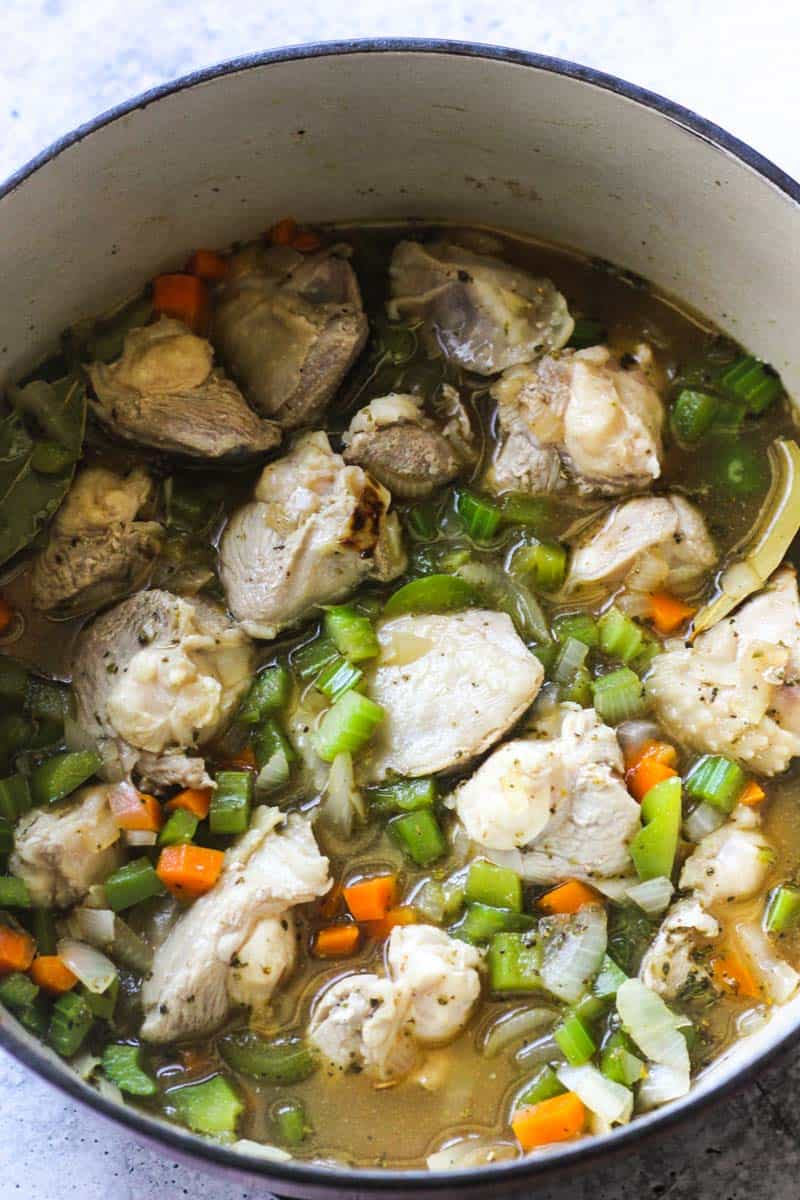 cooking poultry with celery and carrots in rich broth in large pot