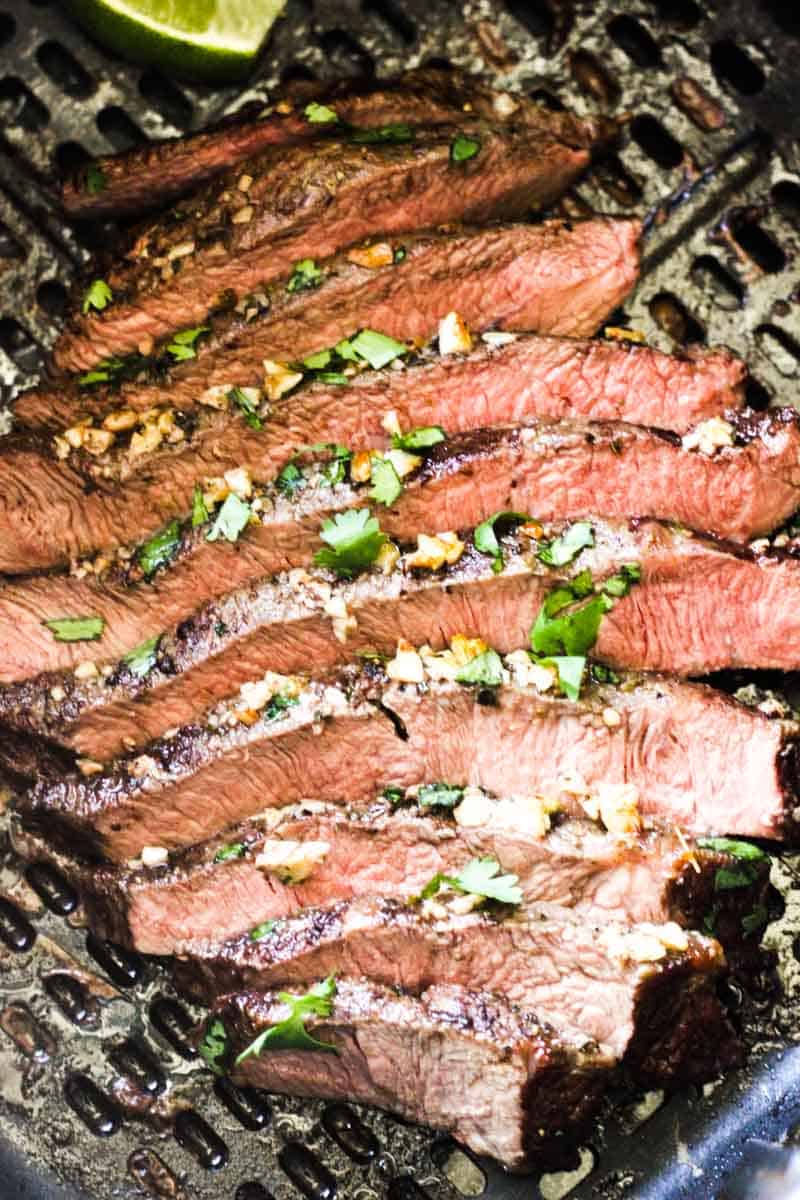 sliced flat iron steak cooked in air fryer with chopped cilantro on top
