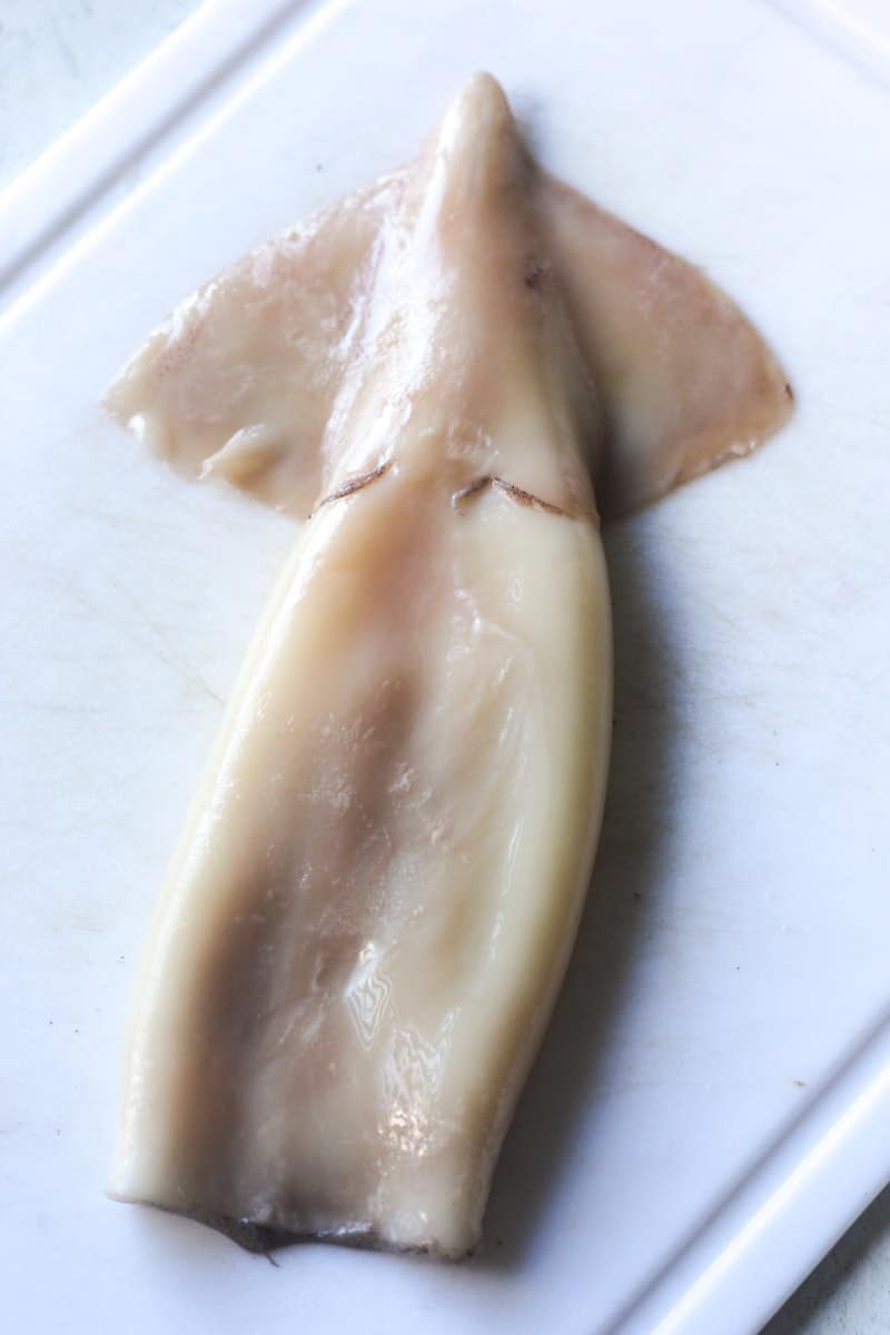 peeled ika squid on the white cutting board