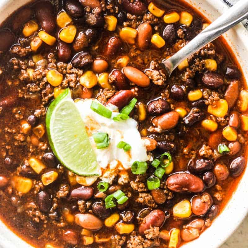 bison chili in the bowl with lime slice on top and a scoop of sour cream