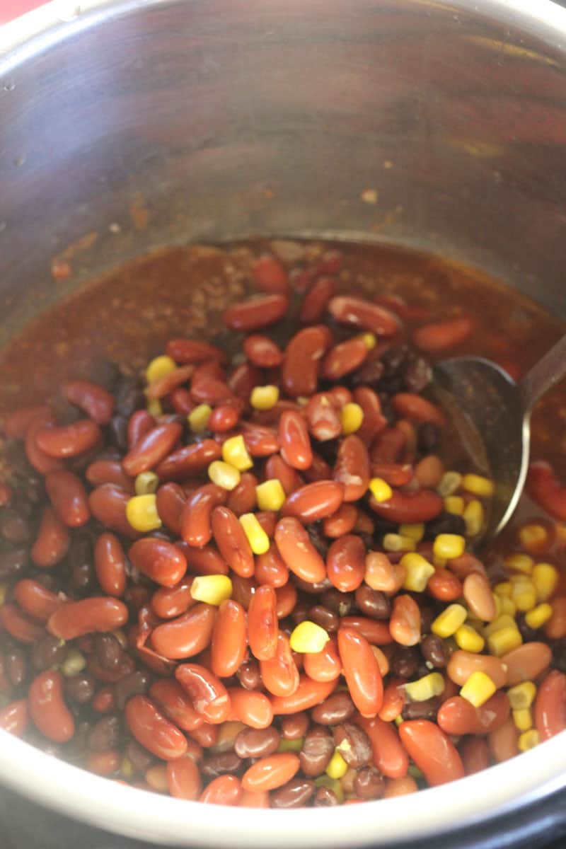 adding beans and corn to the pot
