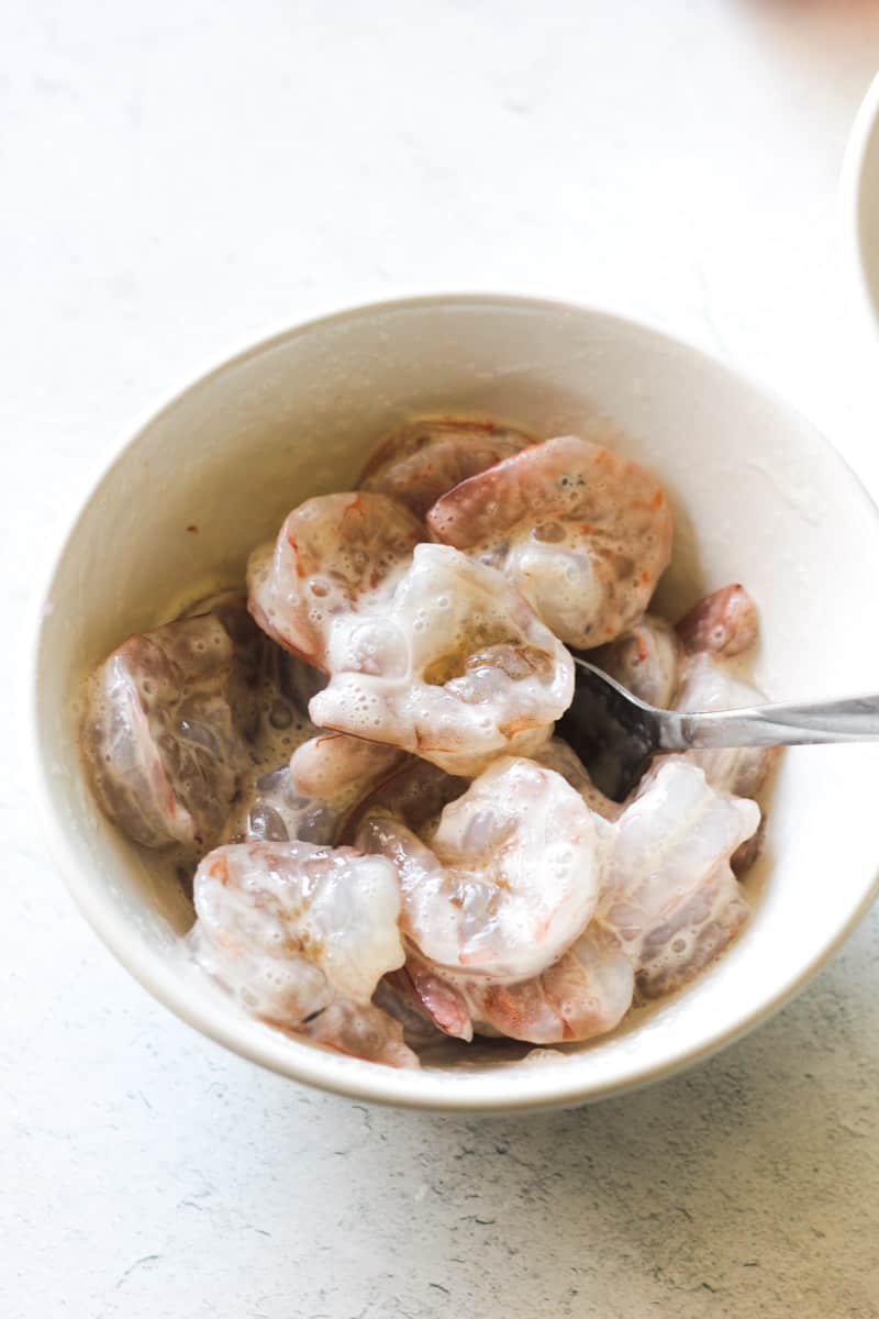 egg whites covered shrimp in a small white bowl