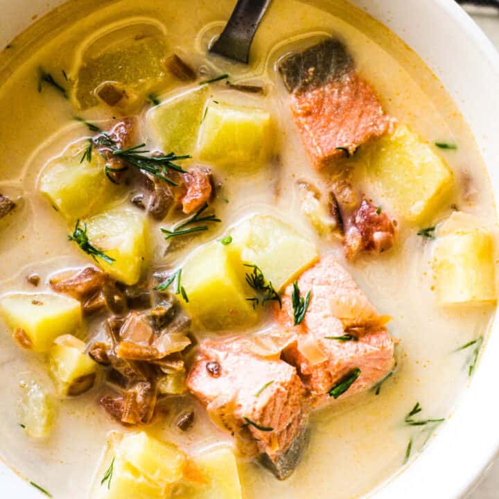 creamy salmon head soup with chopped dill on top