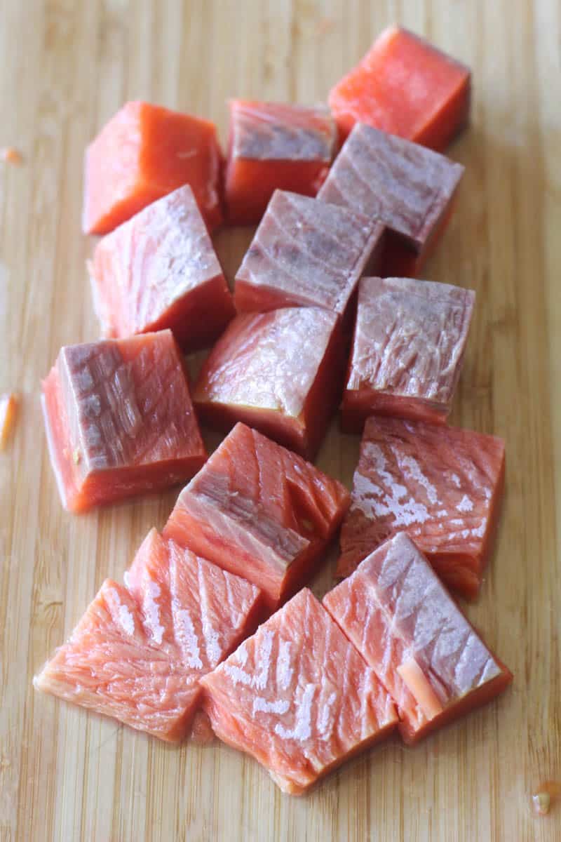 cubes of raw fish on the cutting board