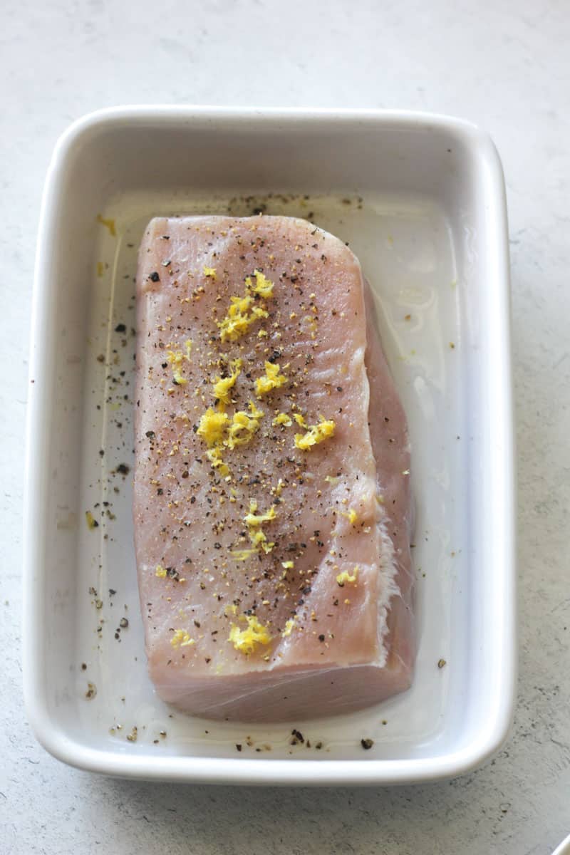 raw fish with lemon peel and ground black pepper on top