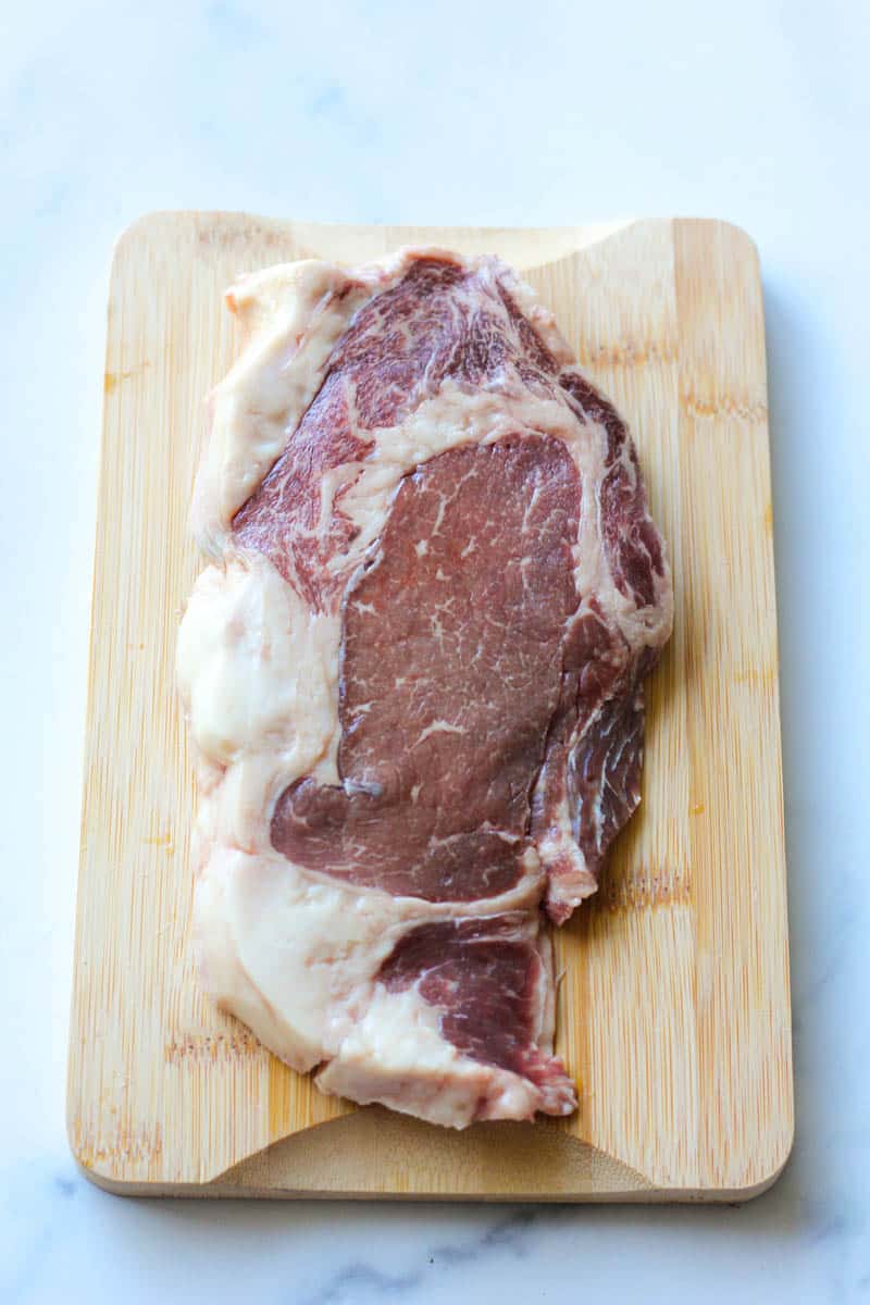 raw bison steak on cutting board