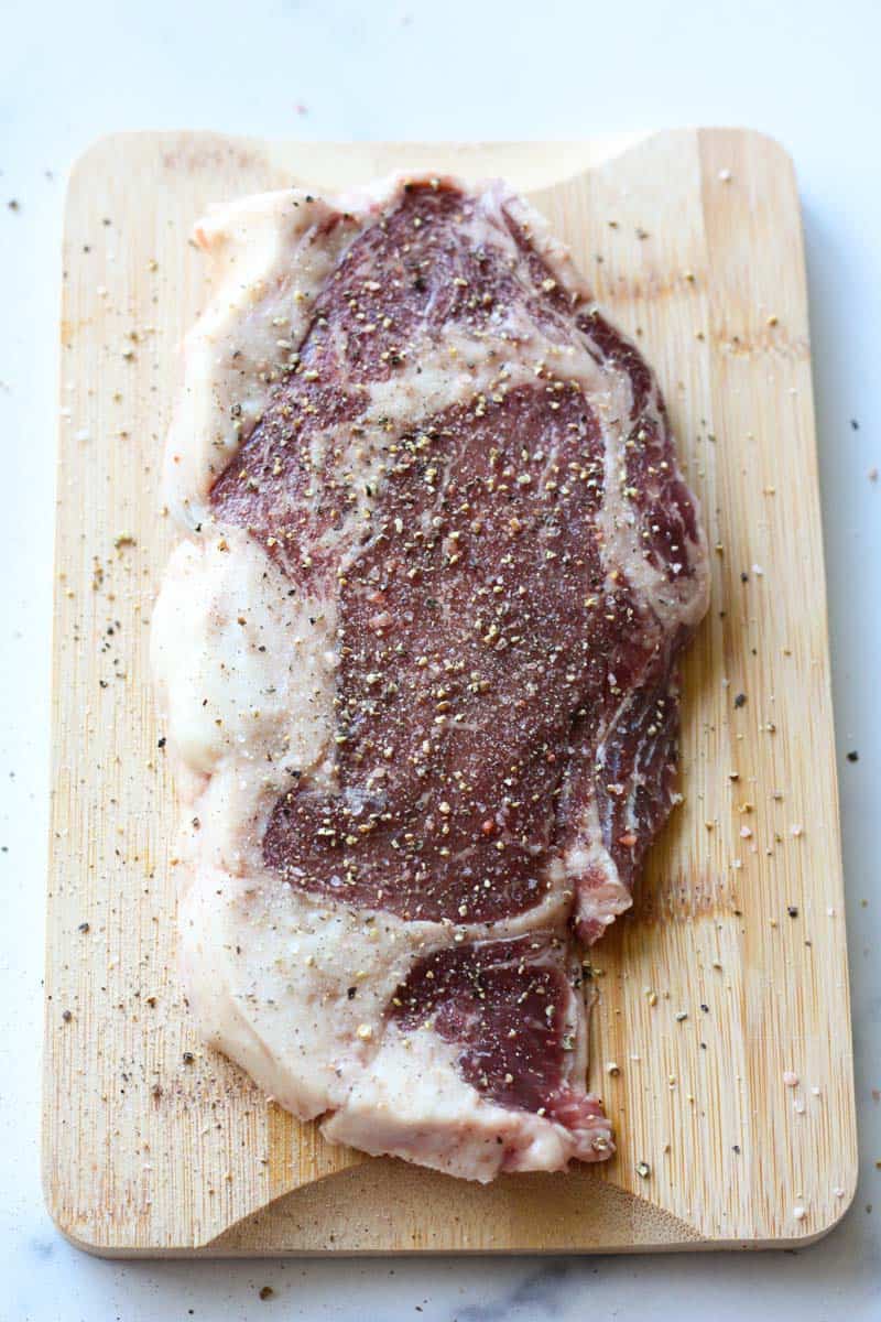 seasoned raw piece of red meat on the cutting board